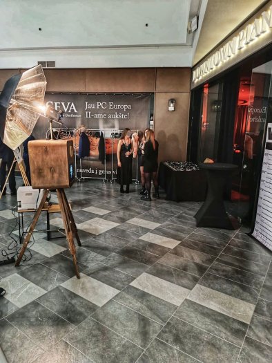 Fotobūdelė įmonių renginyje prekybos centre su svečiais fone