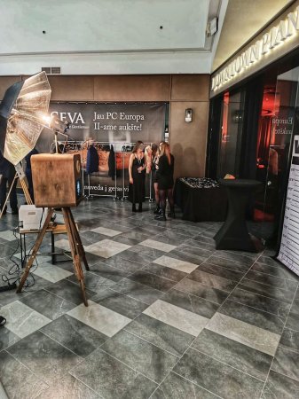 Fotobūdelė įmonių renginyje prekybos centre su svečiais fone